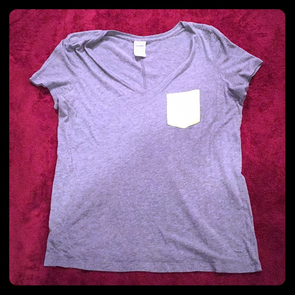 a grey short sleeved shirt with a green pocket.